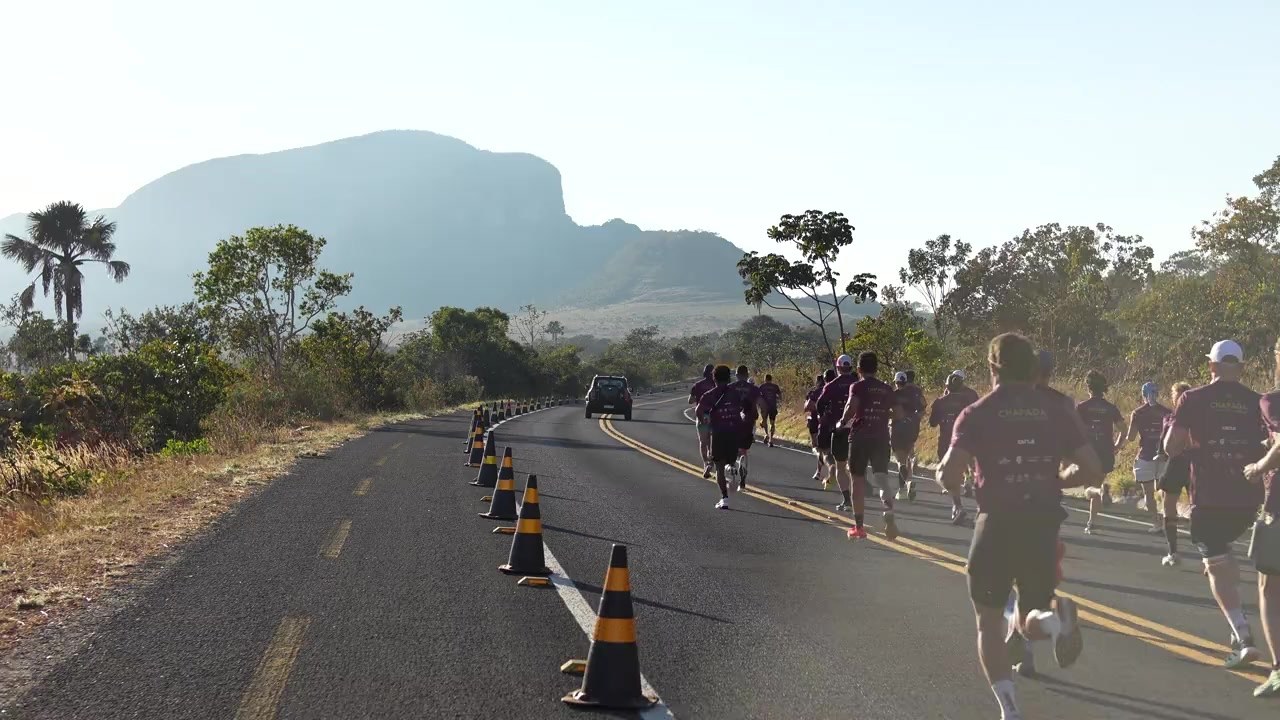 Atletas correndo por uma estrada entre as paisagens da Chapada dos Veadeiros